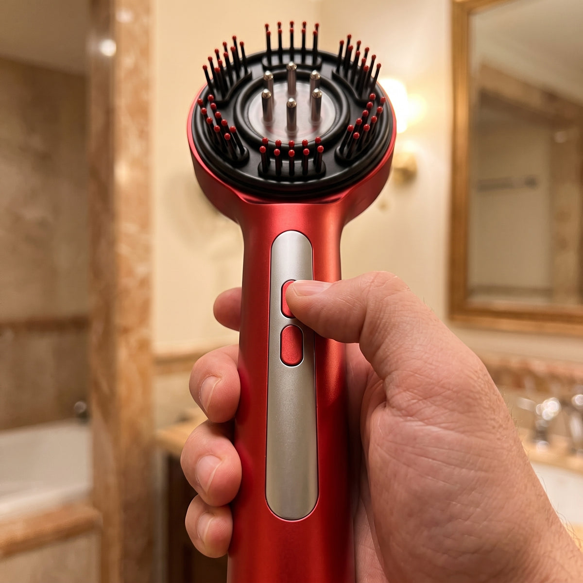 Red scalp massager held in hand